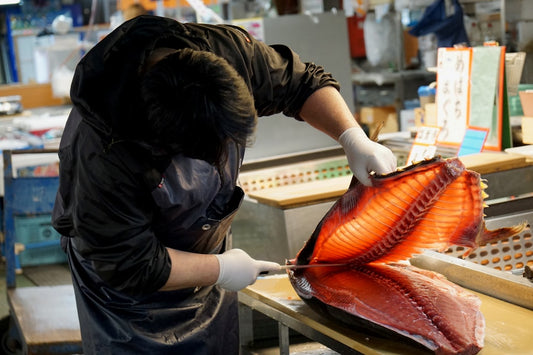 Japanese slicing knife cutting through fish fillet with precision