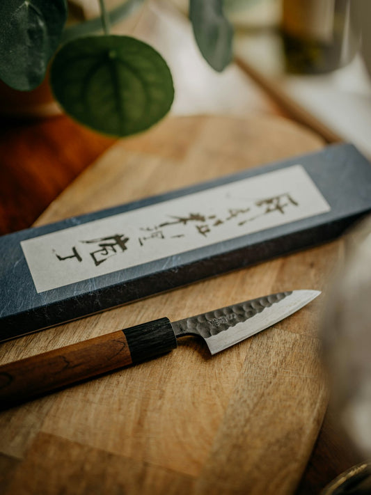 Bunka Japanese knife with distinctive angled tip on cutting board