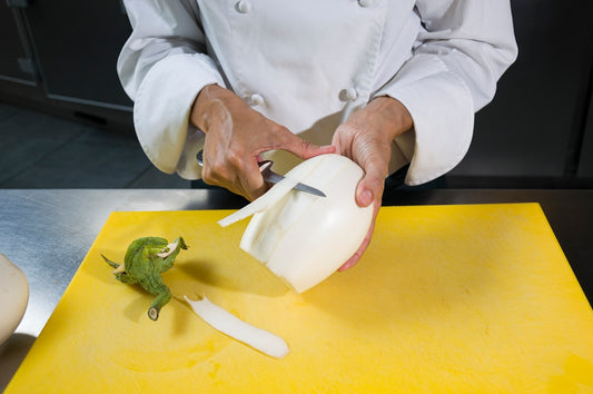 Fresh garlic being minced with a chef's knife